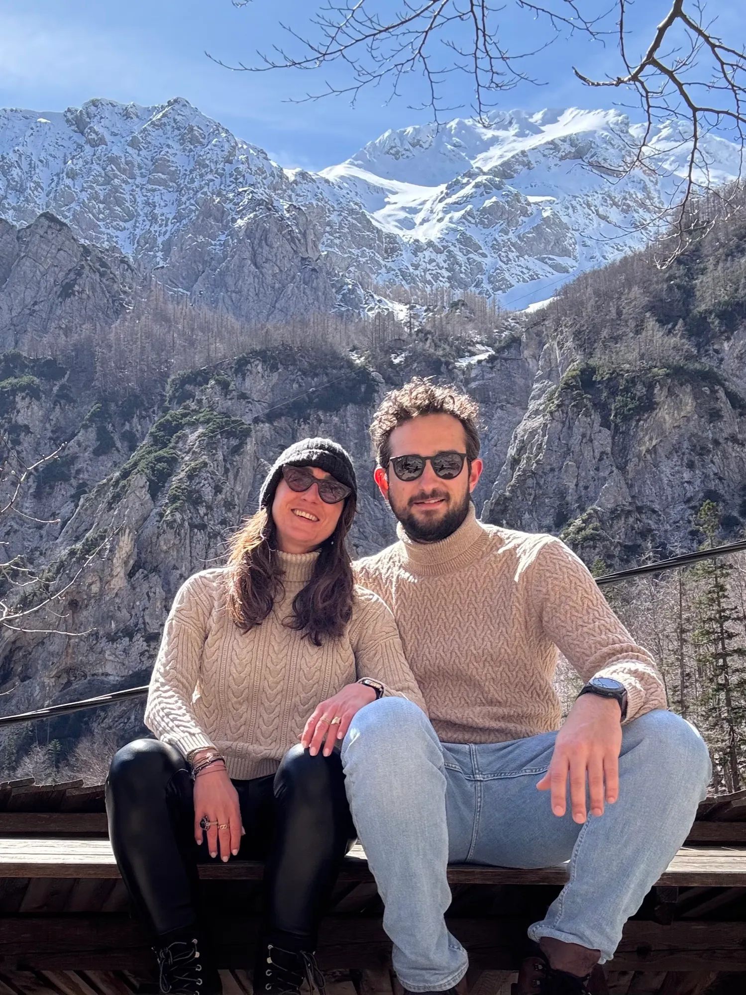 Alejandra and Urban sitting below the snow-covered Kamnik–Savinja Alps